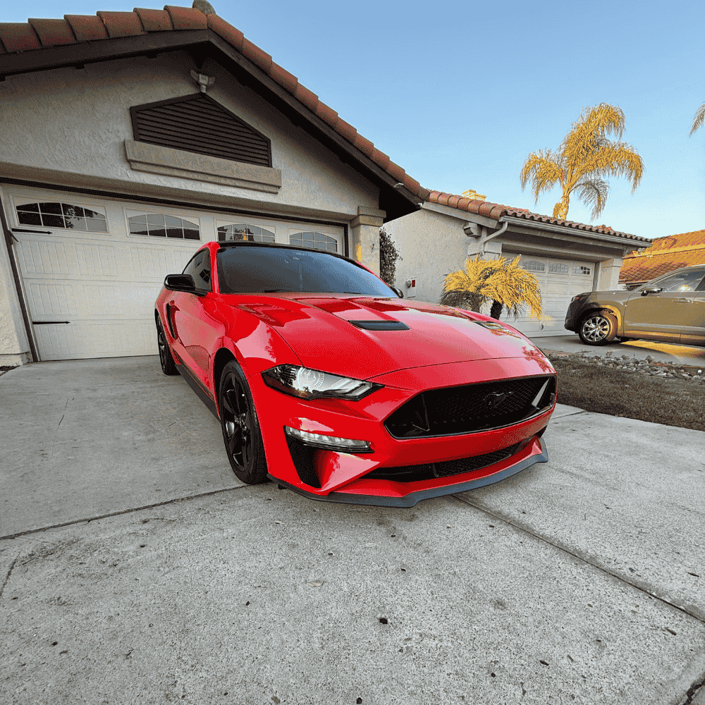 Red Mustang performance car with perfect paint condition and ceramic coating protection in driveway